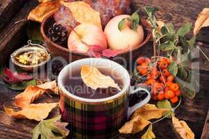 Cup of tea with autumn leaves