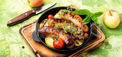 Sausages fried with spices and apple
