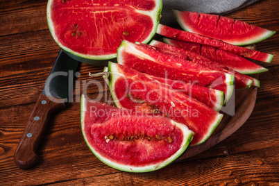 Watermelon slices with knife lying on the board