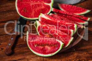 Watermelon slices with knife lying on the board
