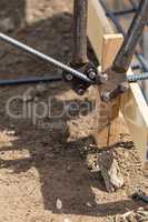 Worker Using Tools To Bend Steel Rebar At Construction Site