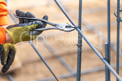 Worker Securing Steel Rebar Framing With Wire Plier Cutter Tool