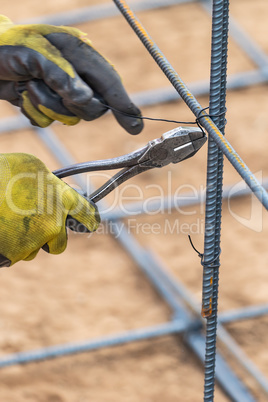 Worker Securing Steel Rebar Framing With Wire Plier Cutter Tool