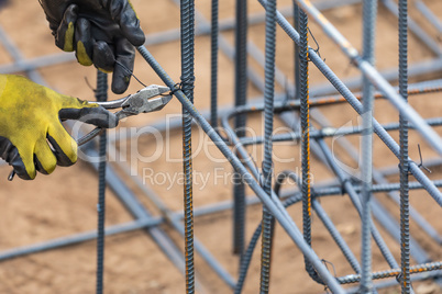 Worker Securing Steel Rebar Framing With Wire Plier Cutter Tool