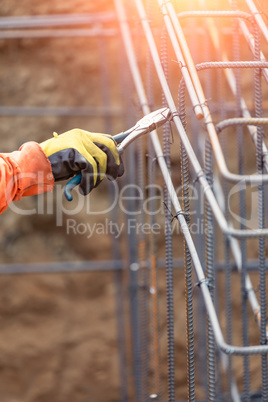 Worker Securing Steel Rebar Framing With Wire Plier Cutter Tool