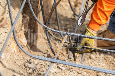 Worker Securing Steel Rebar Framing With Wire Plier Cutter Tool