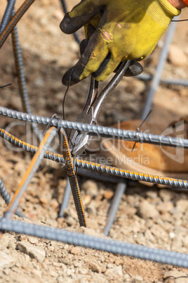 Worker Securing Steel Rebar Framing With Wire Plier Cutter Tool