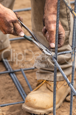 Worker Securing Steel Rebar Framing With Wire Plier Cutter Tool