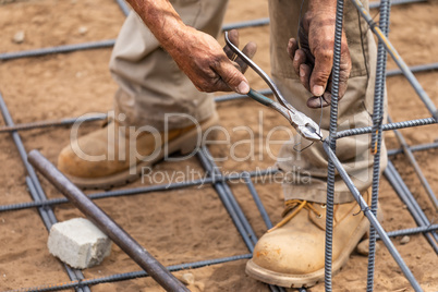 Worker Securing Steel Rebar Framing With Wire Plier Cutter Tool