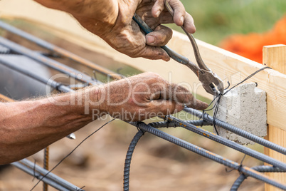 Worker Securing Steel Rebar Framing With Wire Plier Cutter Tool