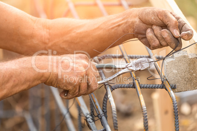 Worker Securing Steel Rebar Framing With Wire Plier Cutter Tool