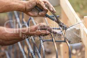 Worker Securing Steel Rebar Framing With Wire Plier Cutter Tool
