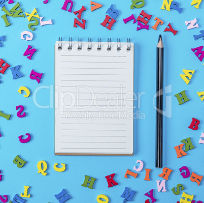open notebook with empty white sheets and black pencil