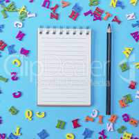 open notebook with empty white sheets and black pencil