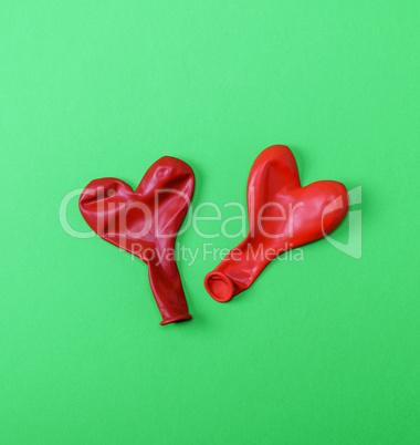 two red rubber balloons blow away in the shape of a heart