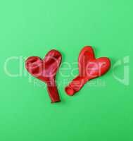 two red rubber balloons blow away in the shape of a heart