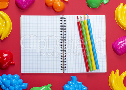 open notebook with empty white sheets in a cell and multicolored