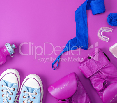 pair of leather pink boxing gloves, a blue textile bandage and a