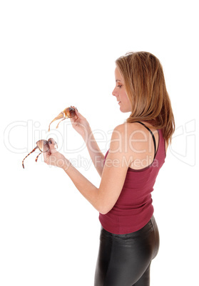 Woman looking at sunglasses witch on to buy