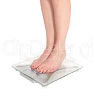 Womans legs standing on a glass scale