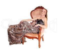 Lovely woman in a long dress sitting in chair