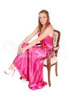 Beautiful woman sitting in a long pink dress