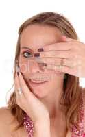 Close up of face of woman holding hand over eye