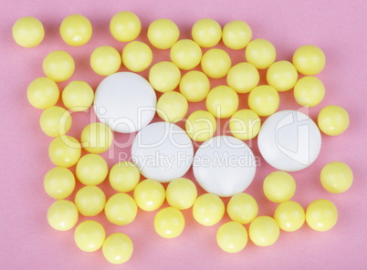 yellow vitamins on pink background