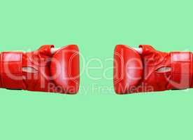 two female hands is wearing a red leather boxing glove on a gree