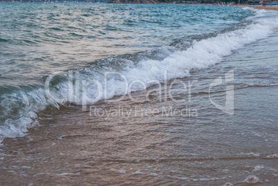 sea surf on a sandy beach on the coast in Greece