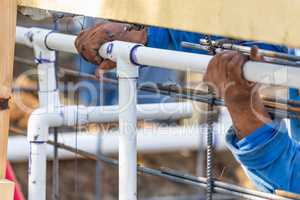 Plumber Installing PVC Pipe at Construction Site