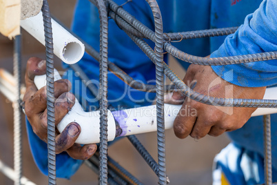 Plumber Installing PVC Pipe at Construction Site