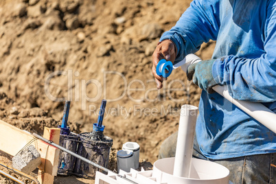 Plumber Applying PTFE Tape To PVC Pipe At Construction Site
