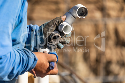 Plumber Applying Pipe Cleaner, Primer and Glue to PVC Pipe