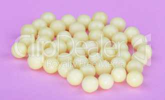 yellow vitamins on pink background