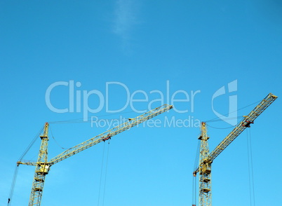 two crane towers on sky background