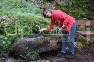 Frau an einem Brunnen