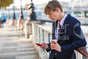 Male Young Adult Teenager Using Cell Phone Drinking Coffee