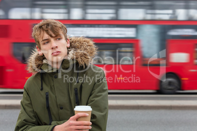 Male Young Adult Teen Drinking Coffee By Red London Bus