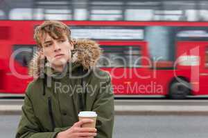 Male Young Adult Teen Drinking Coffee By Red London Bus