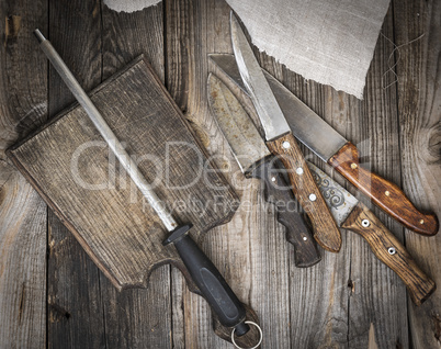 old brown wooden cutting board and knife with sharpening on the