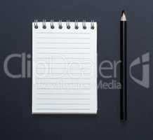 notebook with white sheets in line and black wooden pencil
