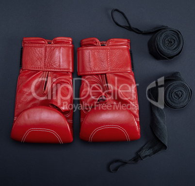 red leather boxing gloves and a black textile bandage