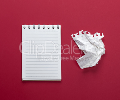 notebook with white sheets and a crumpled  sheet of paper