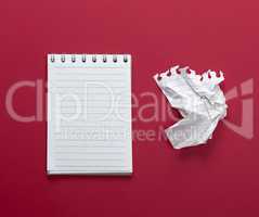notebook with white sheets and a crumpled  sheet of paper