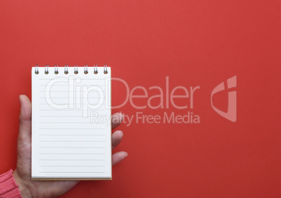 hand holding an open notebook with blank white pages