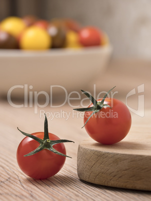 Cherry tomatoes in a variety of colors on a wooden table.