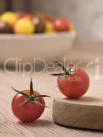 Cherry tomatoes in a variety of colors on a wooden table.
