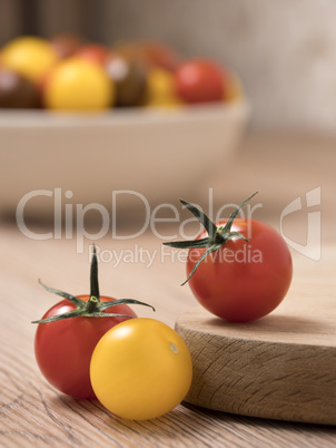 Cherry tomatoes in a variety of colors on a wooden table.