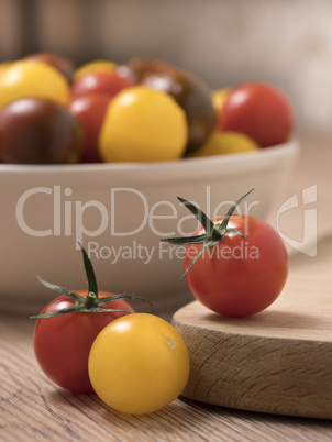 Cherry tomatoes in a variety of colors on a wooden table.